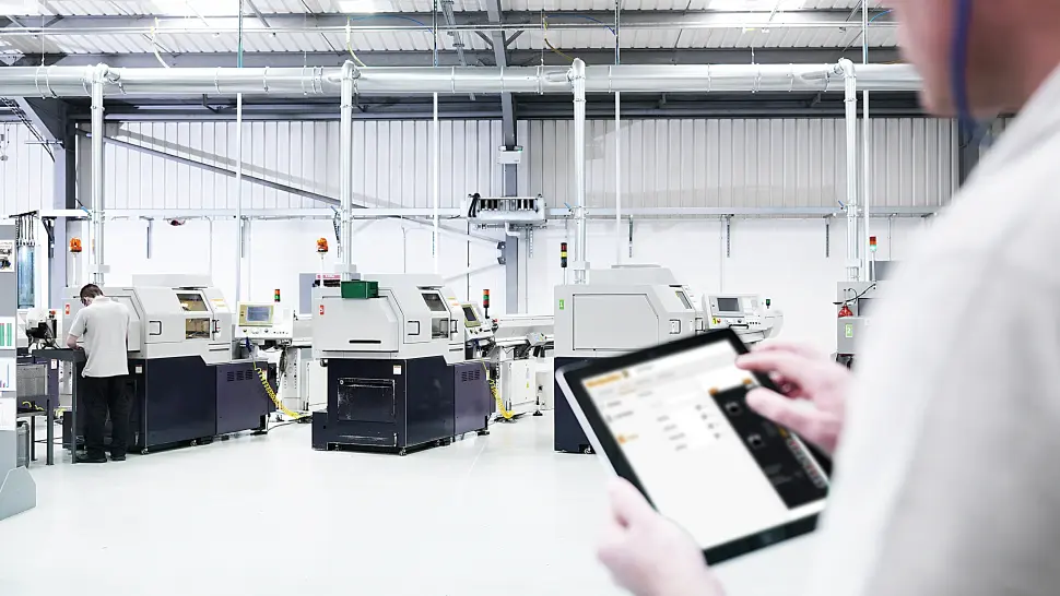 Person with tablet looking at machines